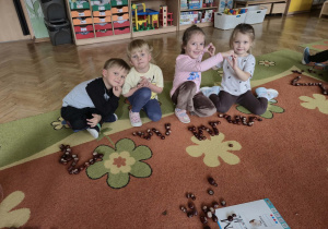 Dzieci układają z kasztanów liyery