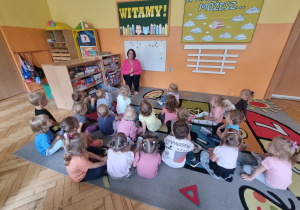 Siedzi siedzą na dywanie podczas zajęć na temat zanieczyszczenia powietrza.