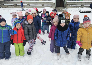 Zabawy w ogrodzie przedszkolnym - dzieci stoją i pozują do zdjęcia