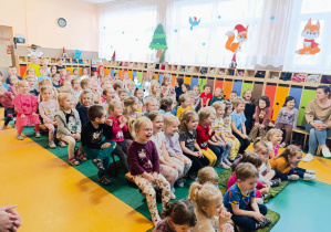 Dzieci oglądają przedstawinie wystawiane w holu przedszkola