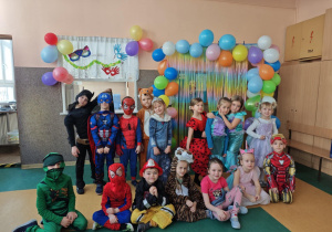 Dzieci w przebraniach karnawałowych na tle balonów
