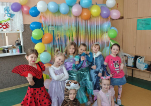 Dziewczynki w strojach karnawałowych na tle balonów