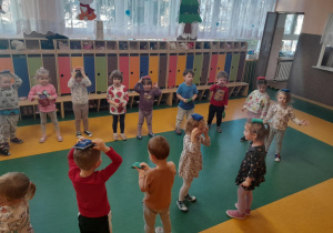 Dzieci wykonują ćwiczenia z woreczkami na sali gimnastycznej.