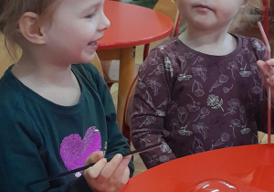 Dwie dziewczynki wykonują doświadczenie z bańkami mydlanymi.