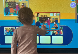 Dziewczynka dopasowuje elementy wyświetlane na ekranie multimedialnym.