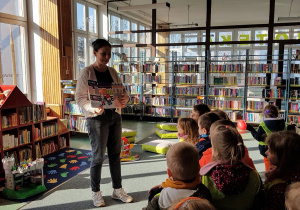 Wizyta w bibliotece - pani bibliotekarka oprowadza dzieci.