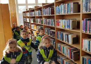 Wizyta w bibliotece - pani bibliotekarka oprowadza dzieci.