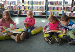 Zajęcia w bibliotece - dzieci oglądają książeczki..