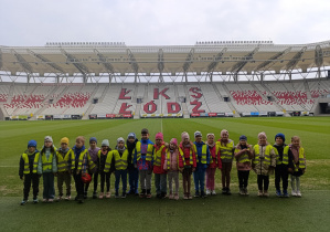 Dzieci pozują do zdjęcia na stadionie piłkarskim