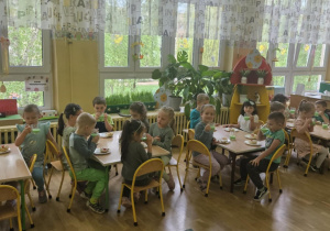 Zielony Dzień - dzieci siedzą przy stolikach i piją zielone mleko