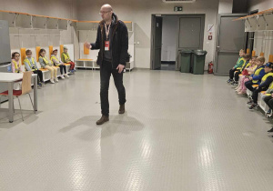 Wycieczka na stadion - dzieci siedzą na miejscach piłkarzy w szatni