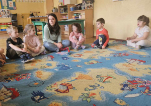 Zabawy o emocjach - dzieci siedzą w kole i rozmawiają z prowadzącą o strachu