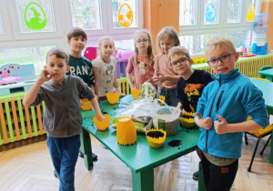 Dzieci wysiewają owies do żółych doniczek