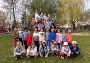 Dzieci pozują do zdjęcia w ogrodzie przedszkolnym