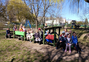 Dzieci pozują do zdjęcia na drewnianym pociągu