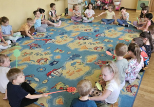 Zabawy z łapkami - dzieci siedzą w kole i podają sobie biedronki za pomocą łapek