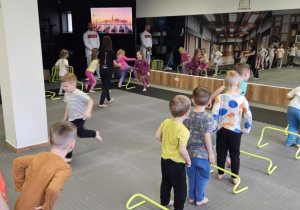 Lekcja sportowa w japońskim DOJO - dzieci ustawione w dwa rzędy przechodzą przez tor przeszkód