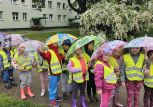 Lekcja sportowa w japońskim DOJO - dzieci pod parasolami, ustawione w parach idą na zajęcia sportowe