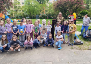 Grupa dzieci pozuje do zdjęcia w ogrodzie przedszkolnym