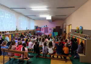 Dzieci oglądają teatrzyk wystawiany w holu przedszkola