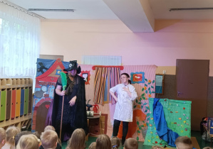 Dzieci oglądają teatrzyk wystawiany w holu przedszkola