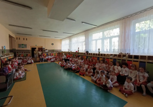 Dzieci ubrane w barwy narodowe uczestniczą w przedszkolnej uroczystości zorganizowanej z okazji Dnia Flagi