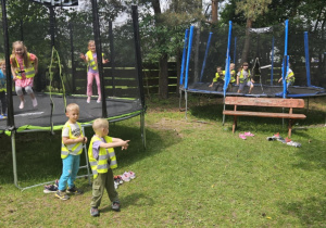Wycieczka do Michałówki - dzieci skaczą na dwóch trampolinach, dwóch chłopców stoi obok