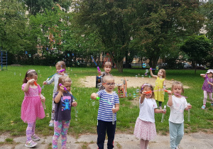 Zabawy w ogrodzie - puszczanie baniek.