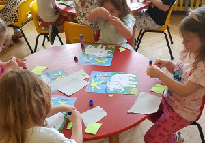 Zajęcia plastyczne - dzieci tworzą prace z papieru kolorowego.