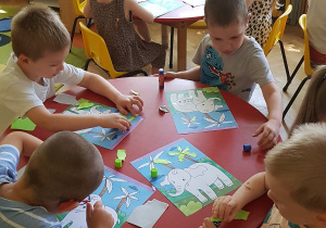 Zajęcia plastyczne - dzieci tworzą prace z papieru kolorowego.