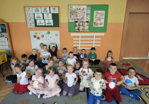 Grupa dzieci trzyma w rękach kolorowe kropki z papieru