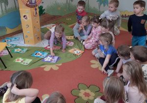 Dziewczynka wybiera zagadkę - kartę.