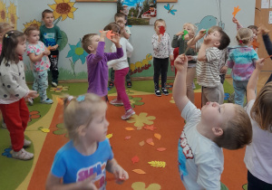 Dzieci dmuchają liście.