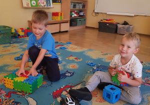 Chłopcy budują z klocków.