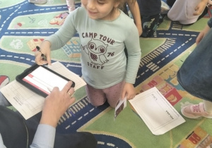 Dziewczynka pisze na elektronicznym tablecie