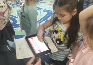 Dziewczynka pisze swoje imię na elektronicznym tablecie