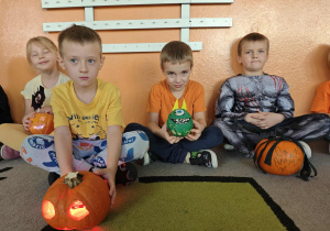 Trzech chłopców pokazuje swoje ozdobione dynie