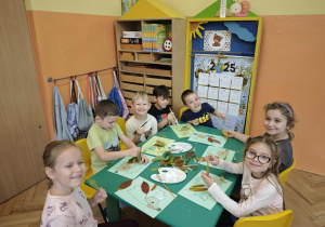 Sześcioro dzieci wykoleja jeża liśćmi