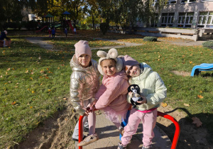Trzy dziewczynki siedzą na karuzeli