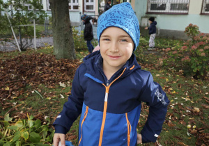 Chłopiec trzyma wiaderko z kasztanami