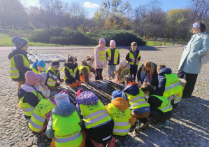 Dzieci stoją nad pamąętkową tablicą