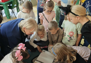Pani pokazuje dzieciom kartki pocztowe