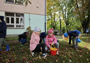 Dwie dziewczynki kucają na trawie