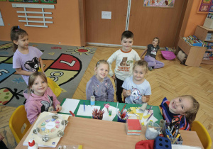 Dzieci uśmiechają się wycinając nożyczkami