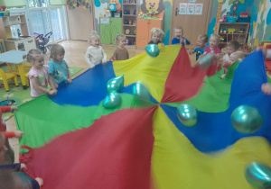 Dzieci trzymają chustę animacyjną przy zabawie