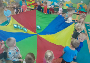 Dzieci utrzymują balony na chuście animacyjnej do piosenki "Wszystkie dzieci nasze są"