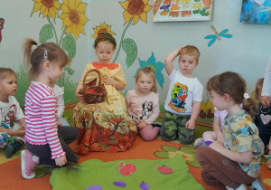 Dzieci przeliczają i zbierają owoce do kosza Pani Jesieni.