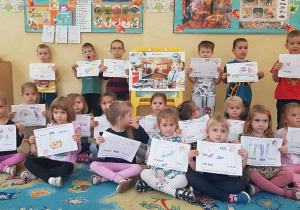 Dzieci prezentują wykonane przez siebie listy do rodziców.