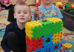 Dzieci prezentują budowlę z klocków.