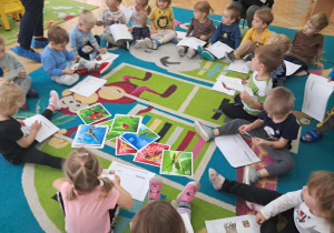 Pan listonosz rozdaje dzieciom znaczki i pocztówki